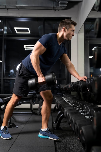 Adulto joven haciendo deporte de interior en el gimnasio