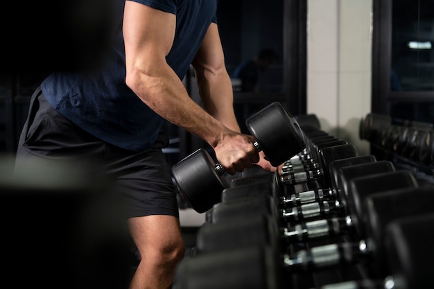 Foto gratuita adulto joven haciendo deporte de interior en el gimnasio