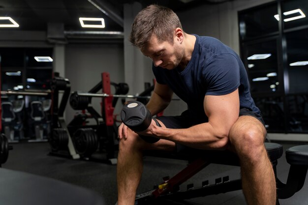 Adulto joven haciendo deporte de interior en el gimnasio