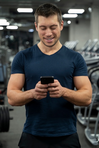 Foto gratuita adulto joven haciendo deporte de interior en el gimnasio