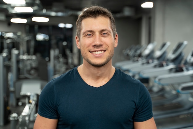 Adulto joven haciendo deporte de interior en el gimnasio