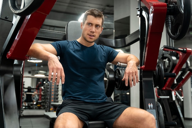 Adulto joven haciendo deporte de interior en el gimnasio