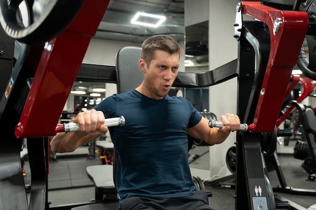 Adulto joven haciendo deporte de interior en el gimnasio