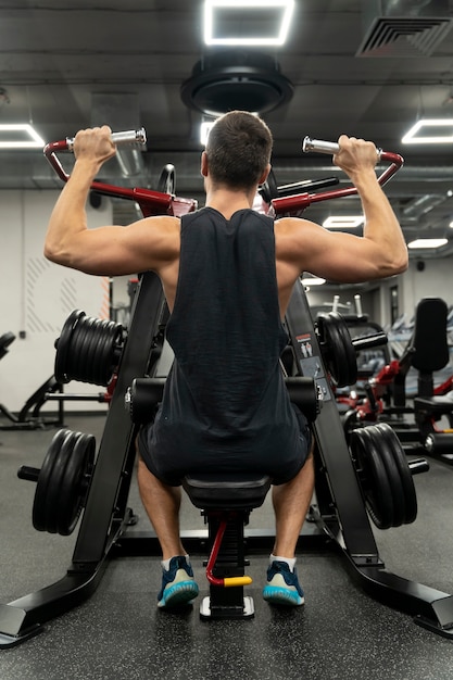 Adulto joven haciendo deporte de interior en el gimnasio