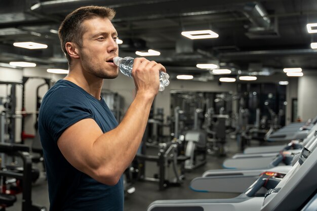 Adulto joven haciendo deporte de interior en el gimnasio