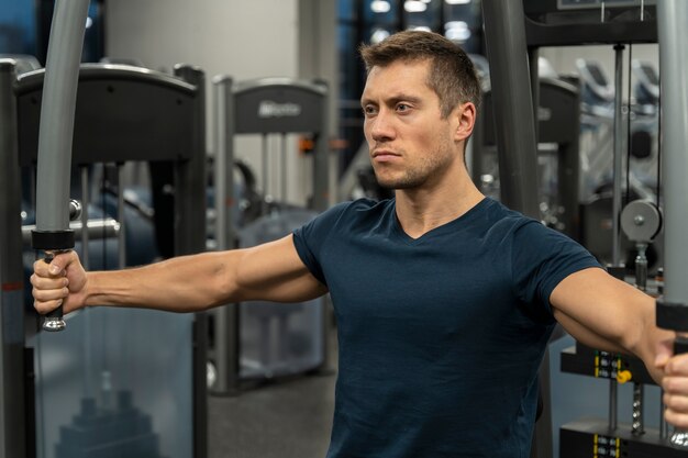 Adulto joven haciendo deporte de interior en el gimnasio