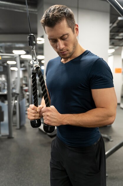 Adulto joven haciendo deporte de interior en el gimnasio