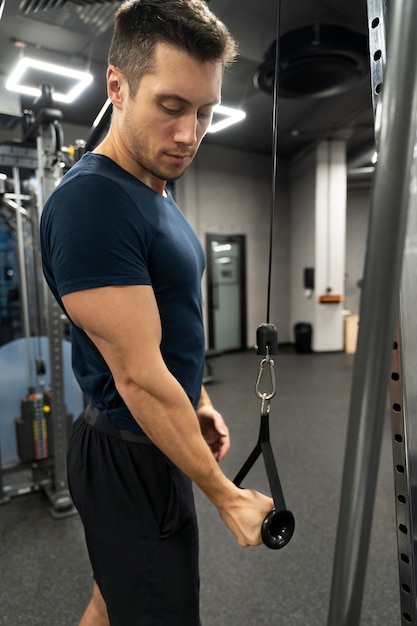 Adulto joven haciendo deporte de interior en el gimnasio