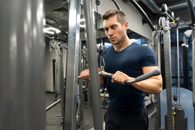 Adulto joven haciendo deporte de interior en el gimnasio