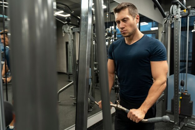 Adulto joven haciendo deporte de interior en el gimnasio