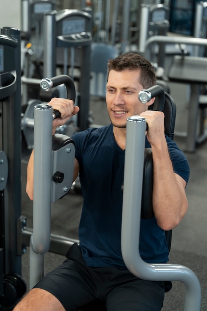 Adulto joven haciendo deporte de interior en el gimnasio