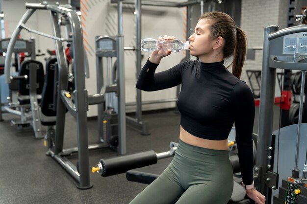 Adulto joven haciendo deporte de interior en el gimnasio