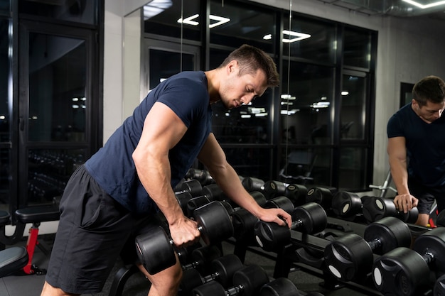 Adulto joven haciendo deporte de interior en el gimnasio