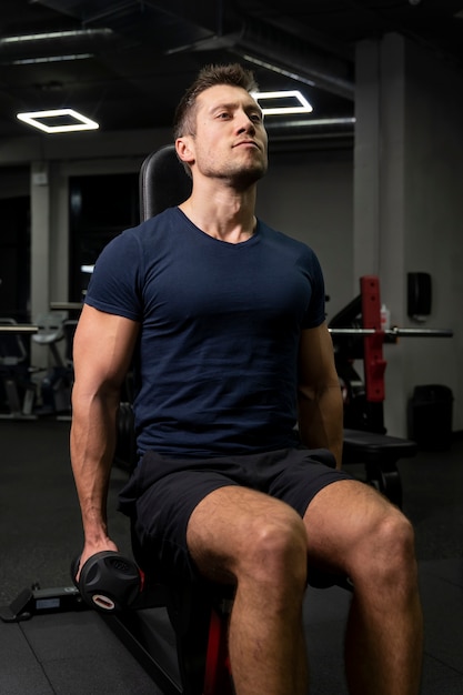 Adulto joven haciendo deporte de interior en el gimnasio