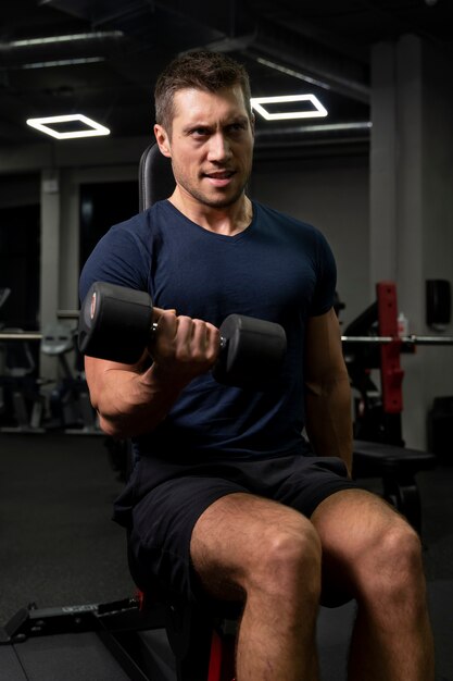 Adulto joven haciendo deporte de interior en el gimnasio