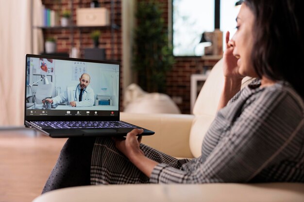 Adulto joven llamando al médico en telesalud por videollamada, hablando sobre el tratamiento de atención médica en videoconferencia y telemedicina. Reunión en teleconferencia remota con médico, cita en línea.