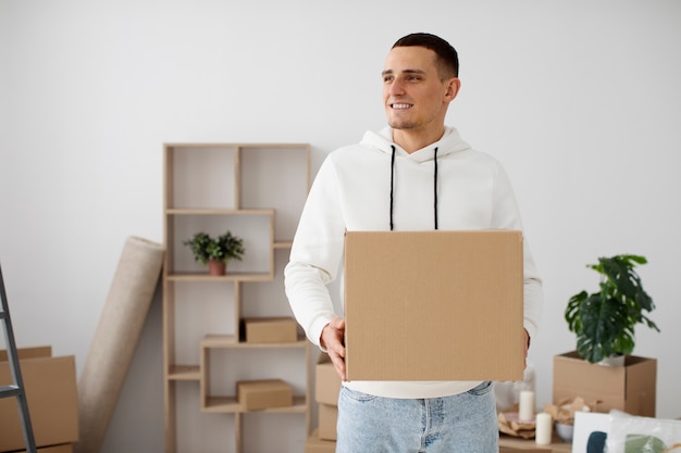 Foto gratuita adulto joven que se muda a una casa nueva