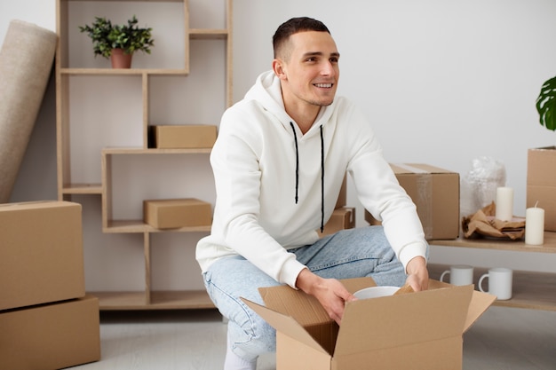 Foto gratuita adulto joven que se muda a una casa nueva