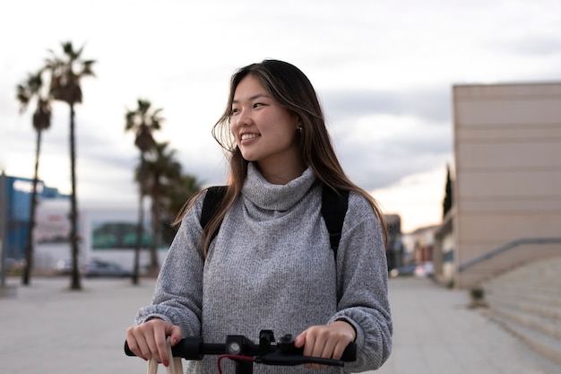 Adulto joven que usa scooter eléctrico para el transporte