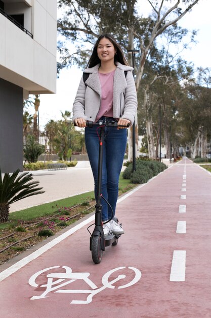 Adulto joven que usa scooter eléctrico para el transporte