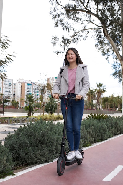 Adulto joven que usa scooter eléctrico para el transporte