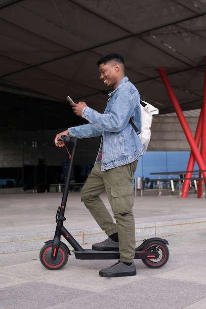 Adulto joven que usa scooter eléctrico para el transporte