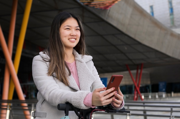 Foto gratuita adulto joven que usa scooter eléctrico para el transporte