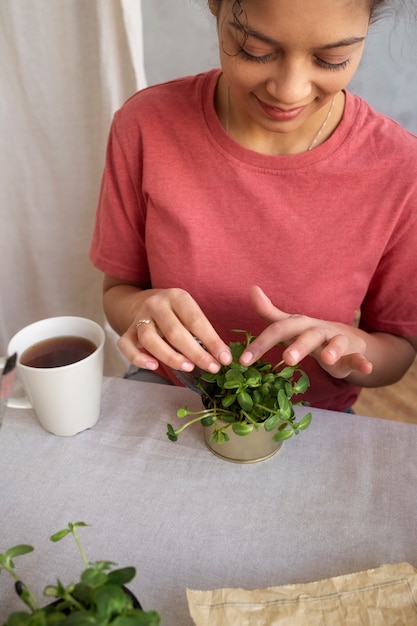 Foto gratuita adulto joven reutilizando latas para plantar