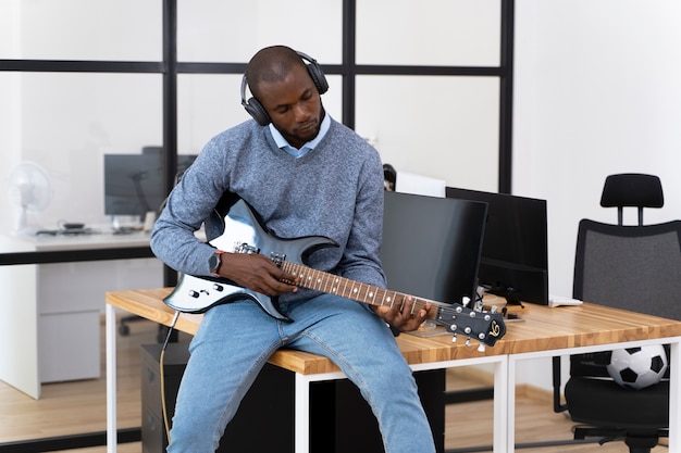 Adulto joven, tocar la guitarra