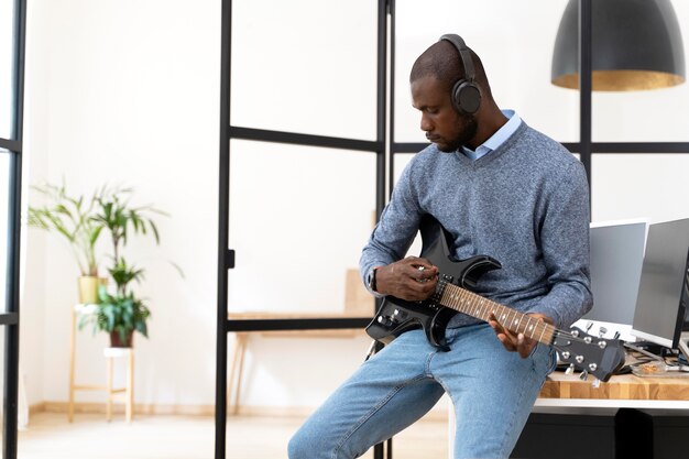 Adulto joven, tocar la guitarra