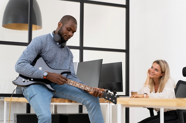 Adulto joven, tocar la guitarra