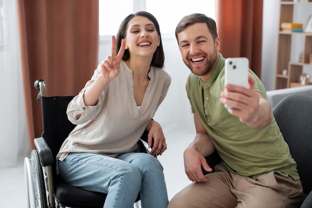 Adulto joven tomando selfie con un amigo discapacitado