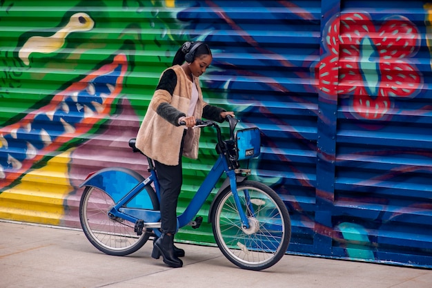 Foto gratuita adulto joven usando bicicleta para viajar en la ciudad