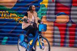 Foto gratuita adulto joven usando bicicleta para viajar en la ciudad