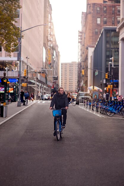 Adulto joven usando bicicleta para viajar en la ciudad