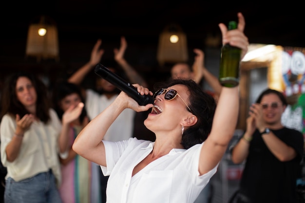 Foto gratuita adultos jóvenes divirtiéndose en micrófono abierto