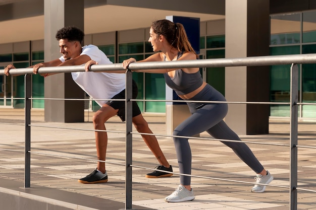 Foto gratuita adultos jóvenes haciendo fitness al aire libre