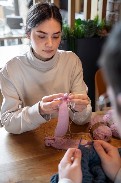 Foto gratuita adultos jóvenes tejiendo afuera