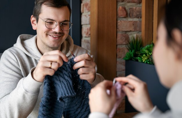 Adultos jóvenes tejiendo afuera