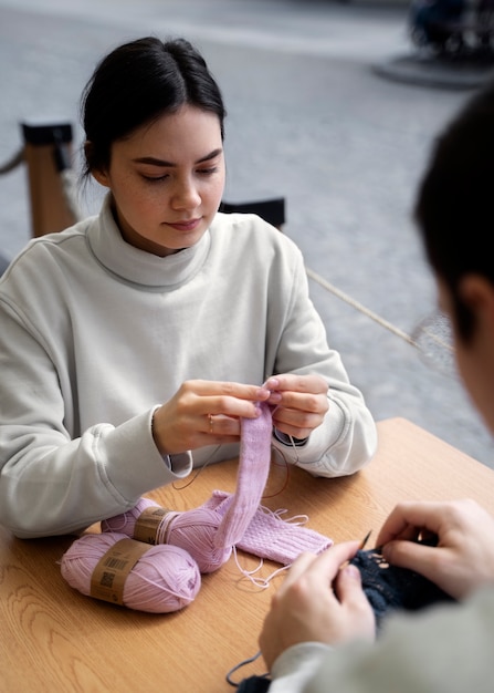 Adultos jóvenes tejiendo afuera