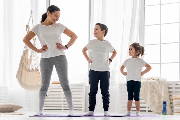 Adultos y niños de tiro completo en estera de yoga