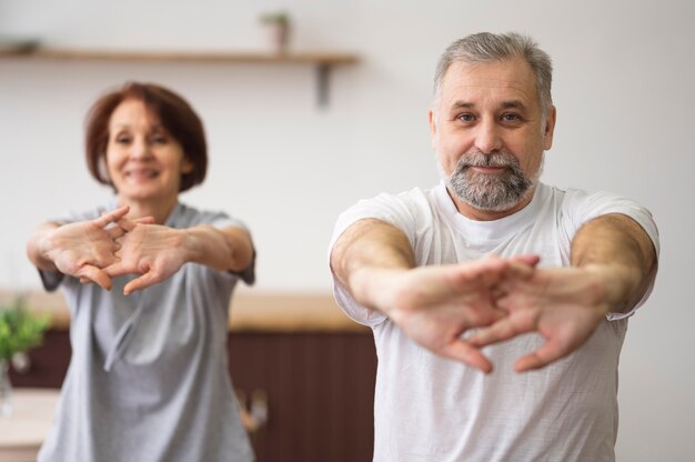 Adultos de tiro medio estirando en interiores