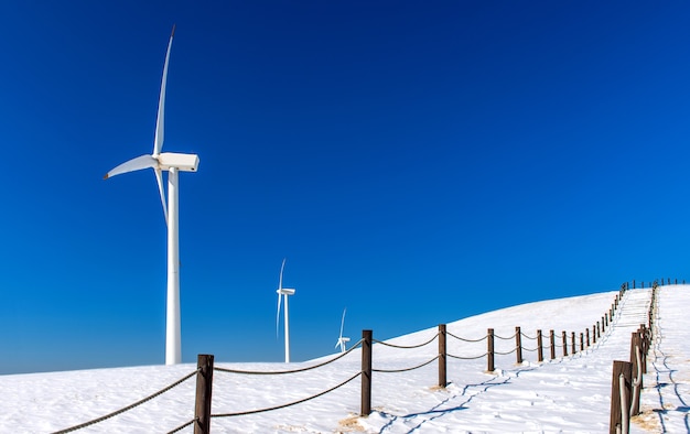 Foto gratuita aerogenerador y cielo azul en paisaje invernal