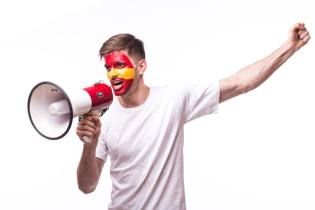 Aficionado al fútbol joven español con megáfono aislado en la pared blanca