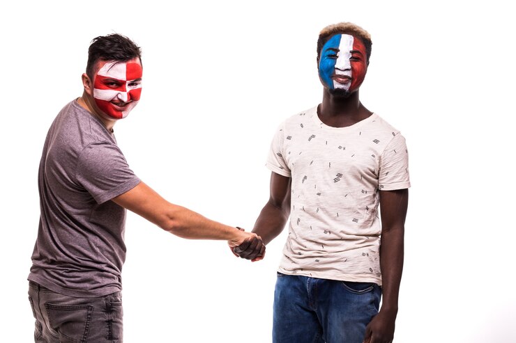 Foto gratuito los aficionados al fútbol de los equipos nacionales de croacia y francia con la cara pintada se dan la mano sobre fondo blanco.