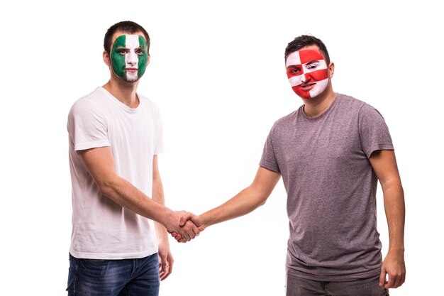 Los aficionados al fútbol de los equipos nacionales de Nigeria y Croacia con la cara pintada se dan la mano