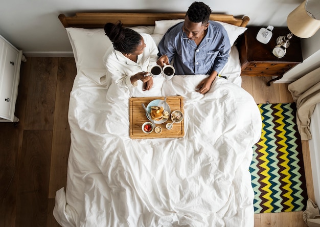 African American pareja en la cama con un desayuno en la cama