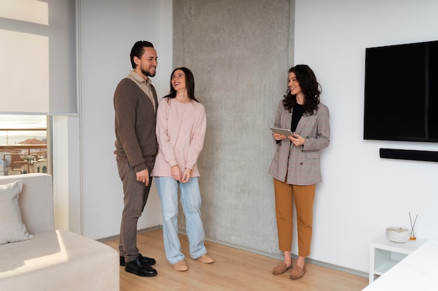 Foto gratuita agente de bienes raíces de tiro completo que muestra la casa