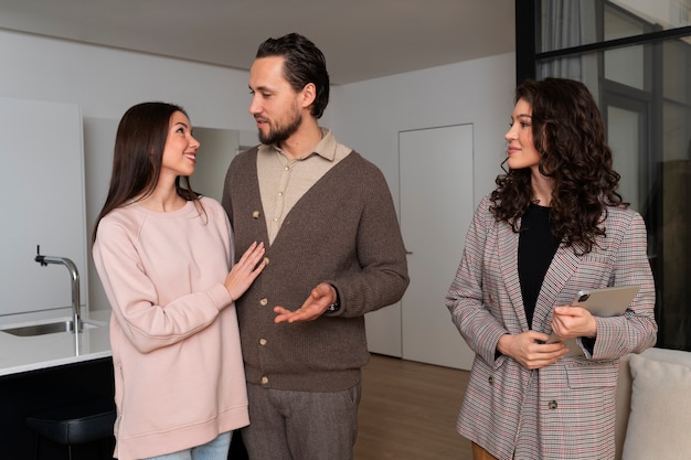 Foto gratuita agente de bienes raíces de tiro medio que muestra la casa