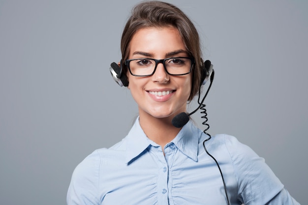 Agente de call center femenino posando con auriculares con micrófono